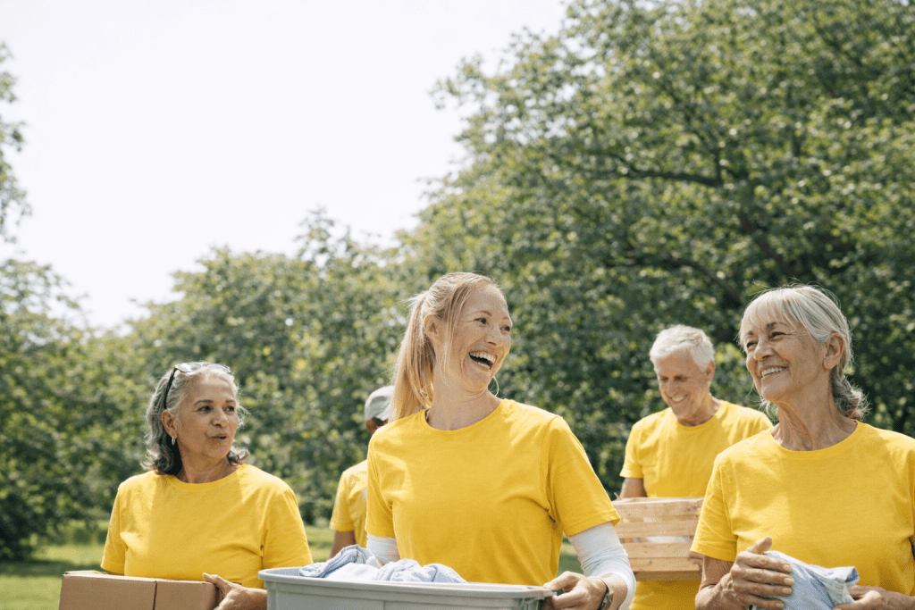 Lions of Manitoba Volunteers Lions volunteers working together outdoors, smiling and carrying supplies in a park setting.
